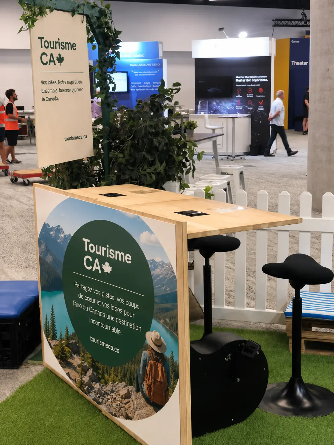 Activation counter with stools and a printed graphic, set up to welcome visitors at a trade show