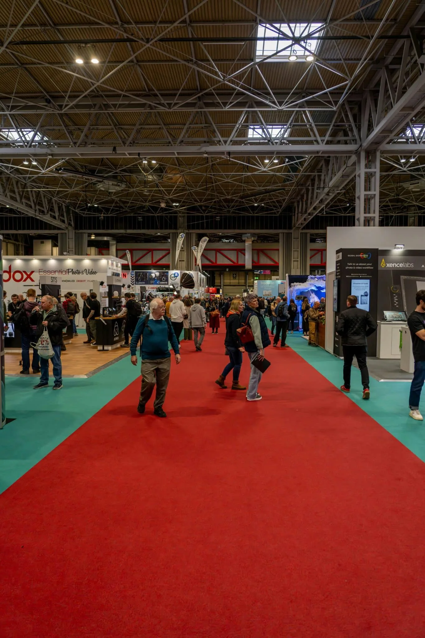 Foule dans un salon professionnel devant des kiosques, dont un kiosque d'exposition modulaire