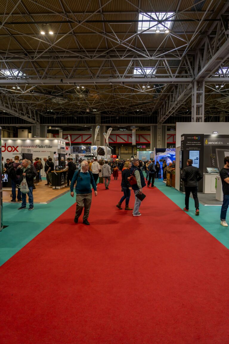 Foule dans un salon professionnel devant des kiosques, dont un kiosque d'exposition modulaire